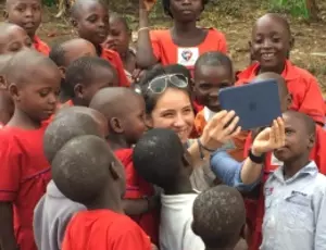 Military engineer takes picture of herself with group of Ugandan kids.
