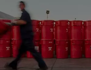 A Veolia employee moves a red barrel among a waste facility
