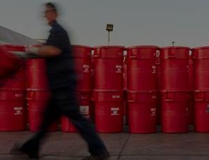 A Veolia employee moves a red barrel among a waste facility
