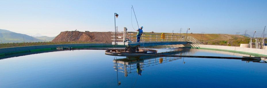 Plant operator testing water in clarifying pool at Rialto Water Services facility.