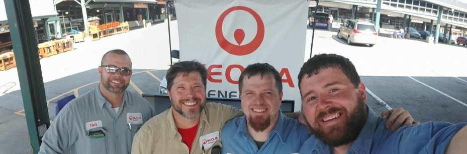 Four Veolia operations staff in front of Veolia booth at the Kansas City Green Fair.
