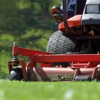 A person drives a residential lawnmower