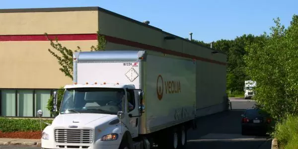 A Veolia truck drives away from a customer facility